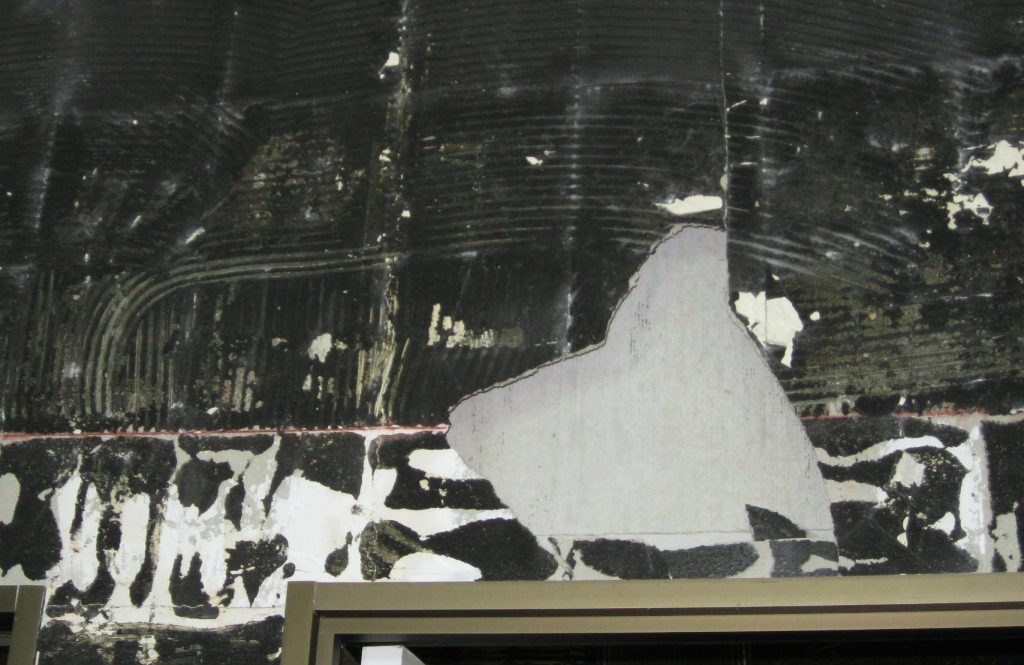 Asbestos cement wall panel covered with asbestos adhesive